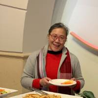 A woman making herself a plate of food at the event